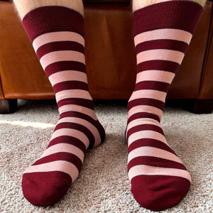 Man wearing a pair of burgundy and blush striped socks