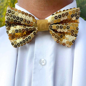 Man wearing a gold sequin bow tie with a white suit jacket