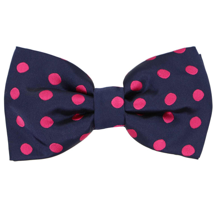 A pre-tied navy blue and fuchsia polka dot pattern bow tie