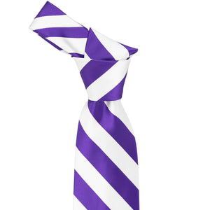 The knot on a purple and white striped tie