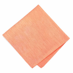 A folded light orange pocket square with a linen texture