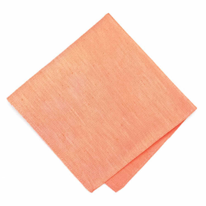 A folded light orange pocket square with a linen texture