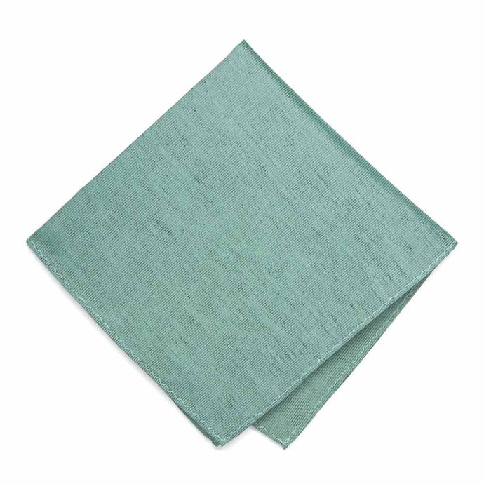 A folded solid dark green pocket square with a stonewashed look