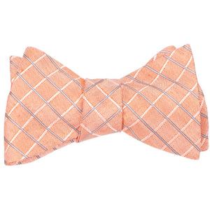 An pre-tied self-tie bow tie in an orange plaid